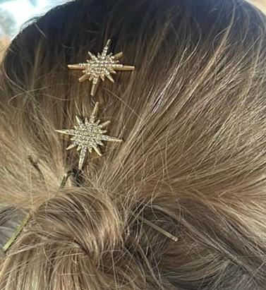 Peina de estrella con 7 puntas cuajada de circonitas en el centro y algunas en las puntas. Consta de dos púas para fijarla al cabello. Imagen como quedan puestas.