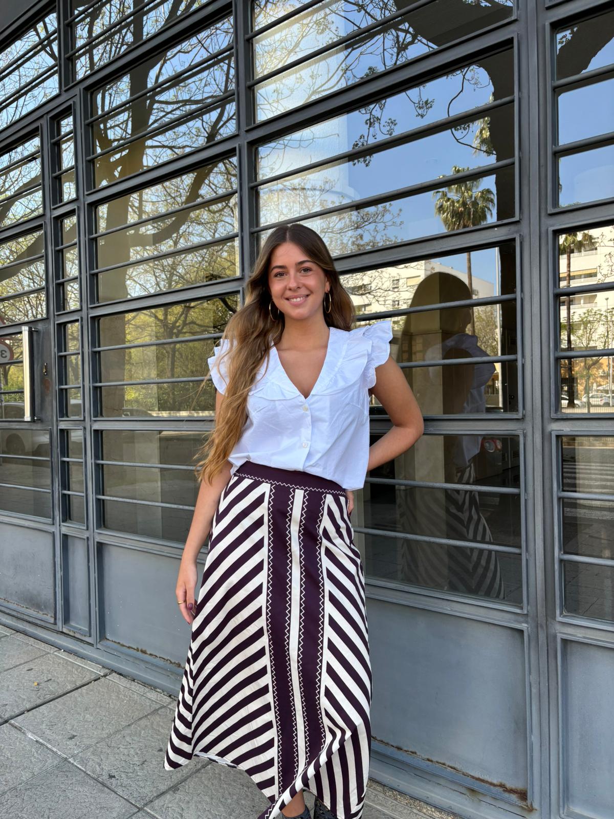 Falda midi de talle alto con estampado geométrico en contraste. Corte fluido y elegante que estiliza la silueta, ideal para looks sofisticados y versátiles.