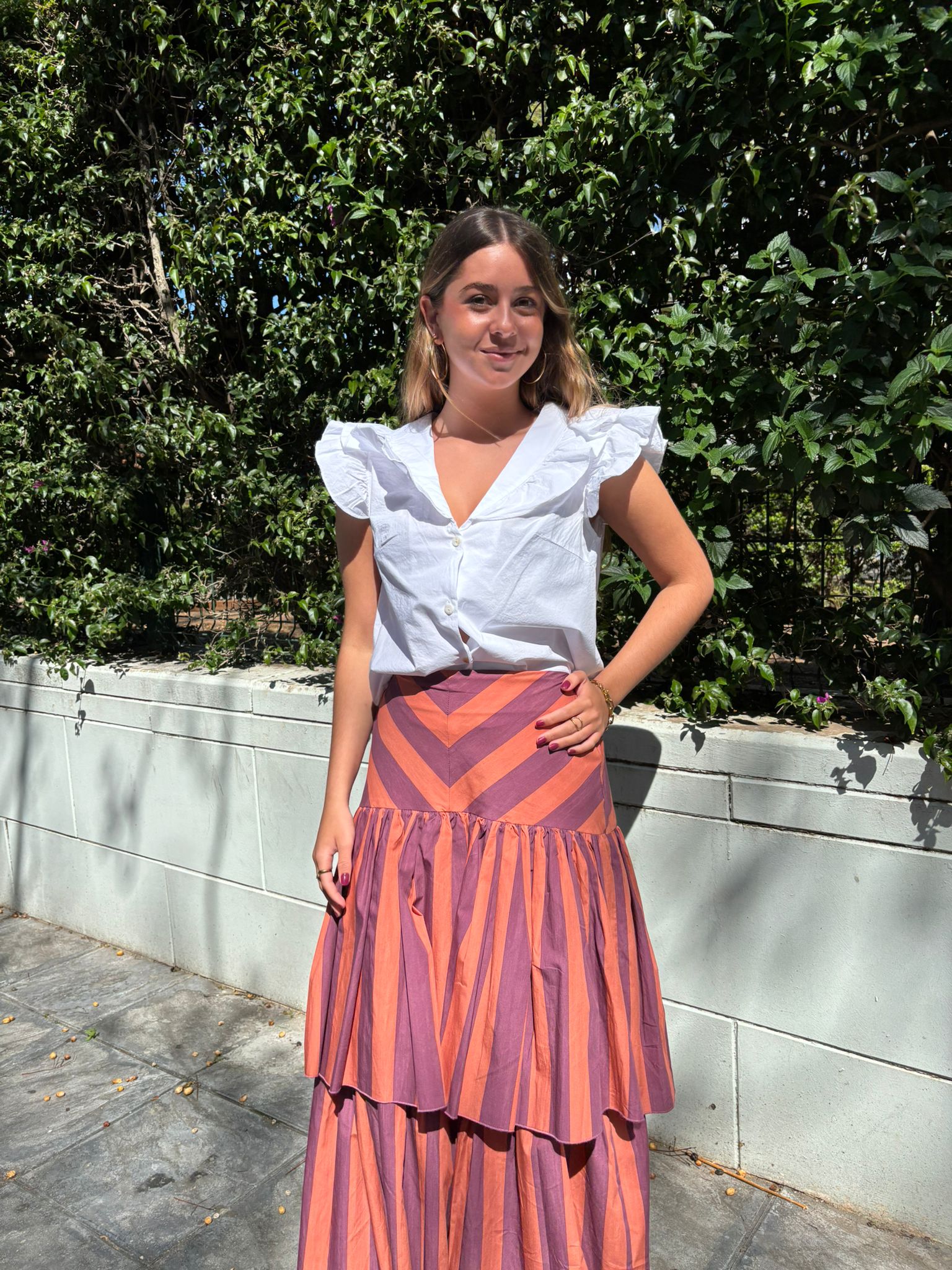 Falda midi de talle alto con diseño de rayas en contraste y cintura en efecto Chevron. Corte con vuelo y doble volante que aporta movimiento y elegancia.