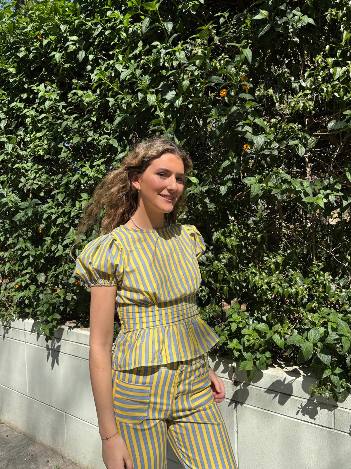 Blusa de rayas entallada con manga abullonada y volante en la cintura.