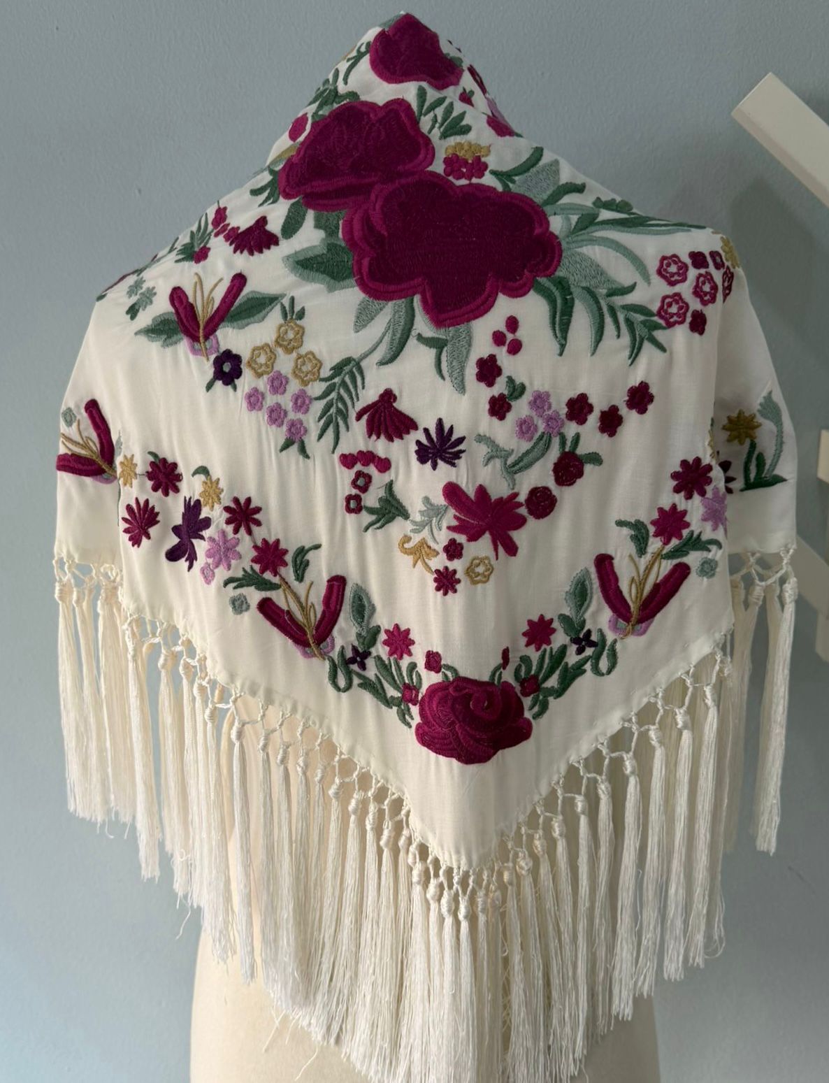 Mantón con bordado floral multicolor en relieve , destacando grandes flores. Acabado con flecos largos y anudado artesanal. Ideal para complementar tu traje de flamenca