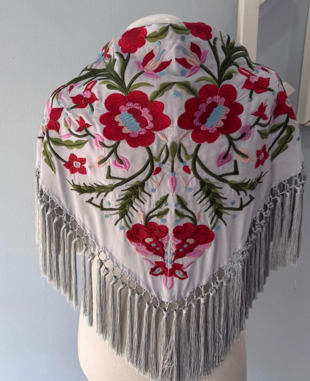 Mantón bordado de Cantillana, con flores de gran detalle y un acabado tradicional espectacular. Con flecos que le dan movimiento y un estilo único, acabado en pico.
