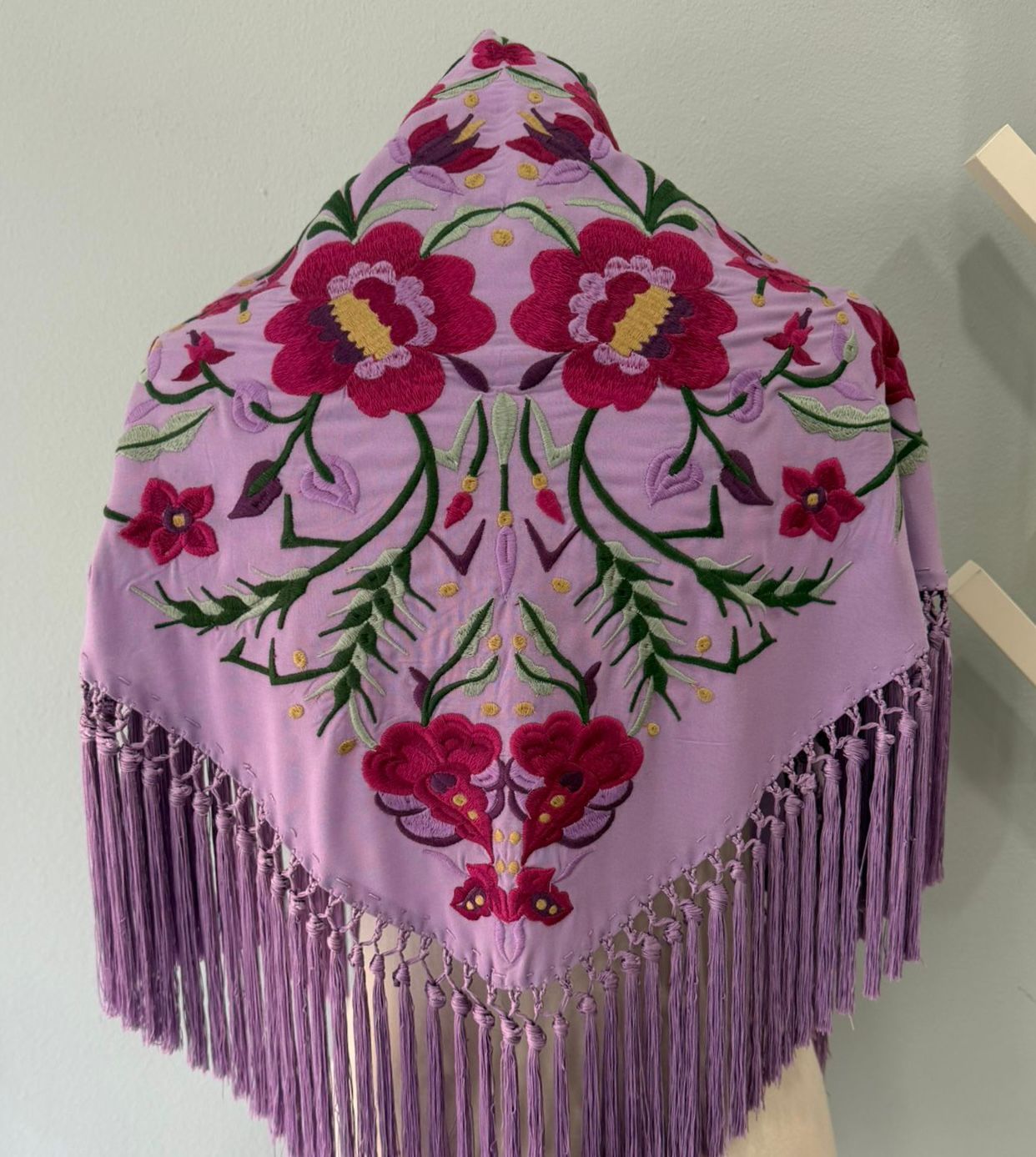 Mantón bordado de Cantillana, con flores de gran detalle y un acabado tradicional espectacular. Con flecos que le dan movimiento y un estilo único, acabado en pico.