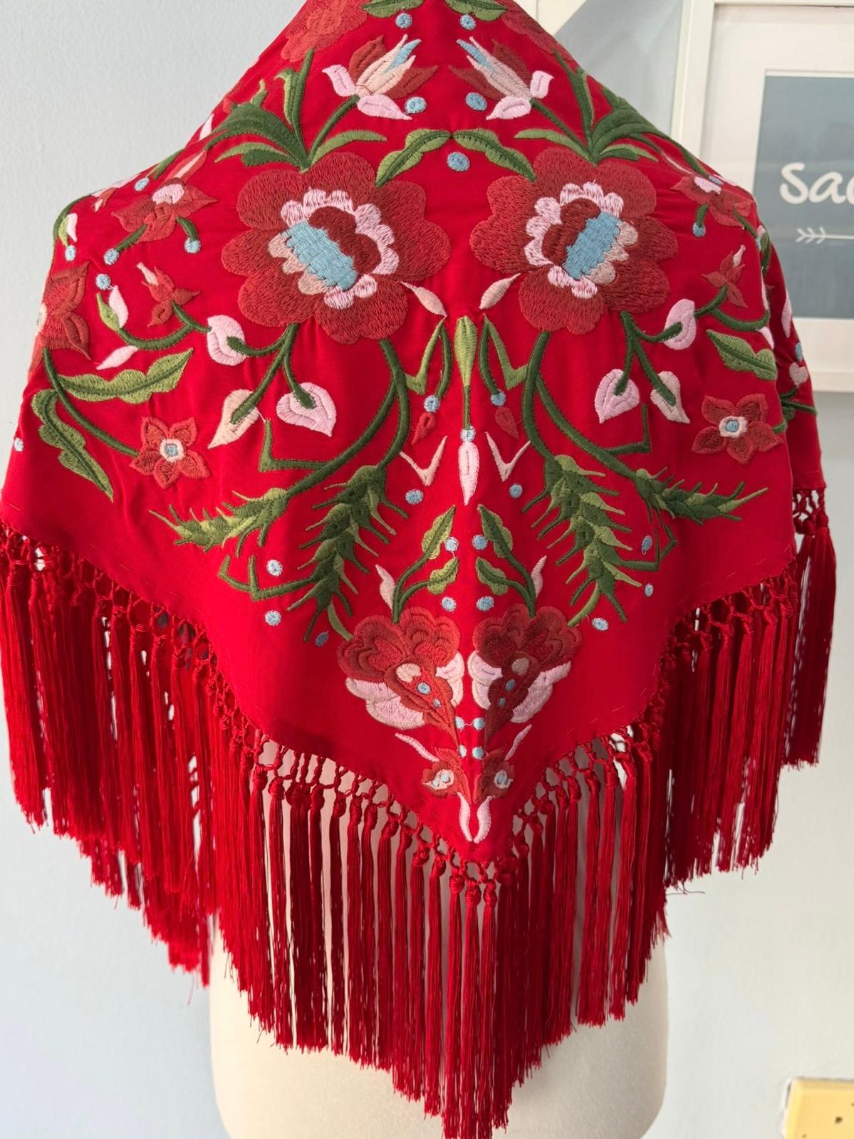 Mantón bordado de Cantillana, con flores de gran detalle y un acabado tradicional espectacular. Con flecos que le dan movimiento y un estilo único, acabado en pico.