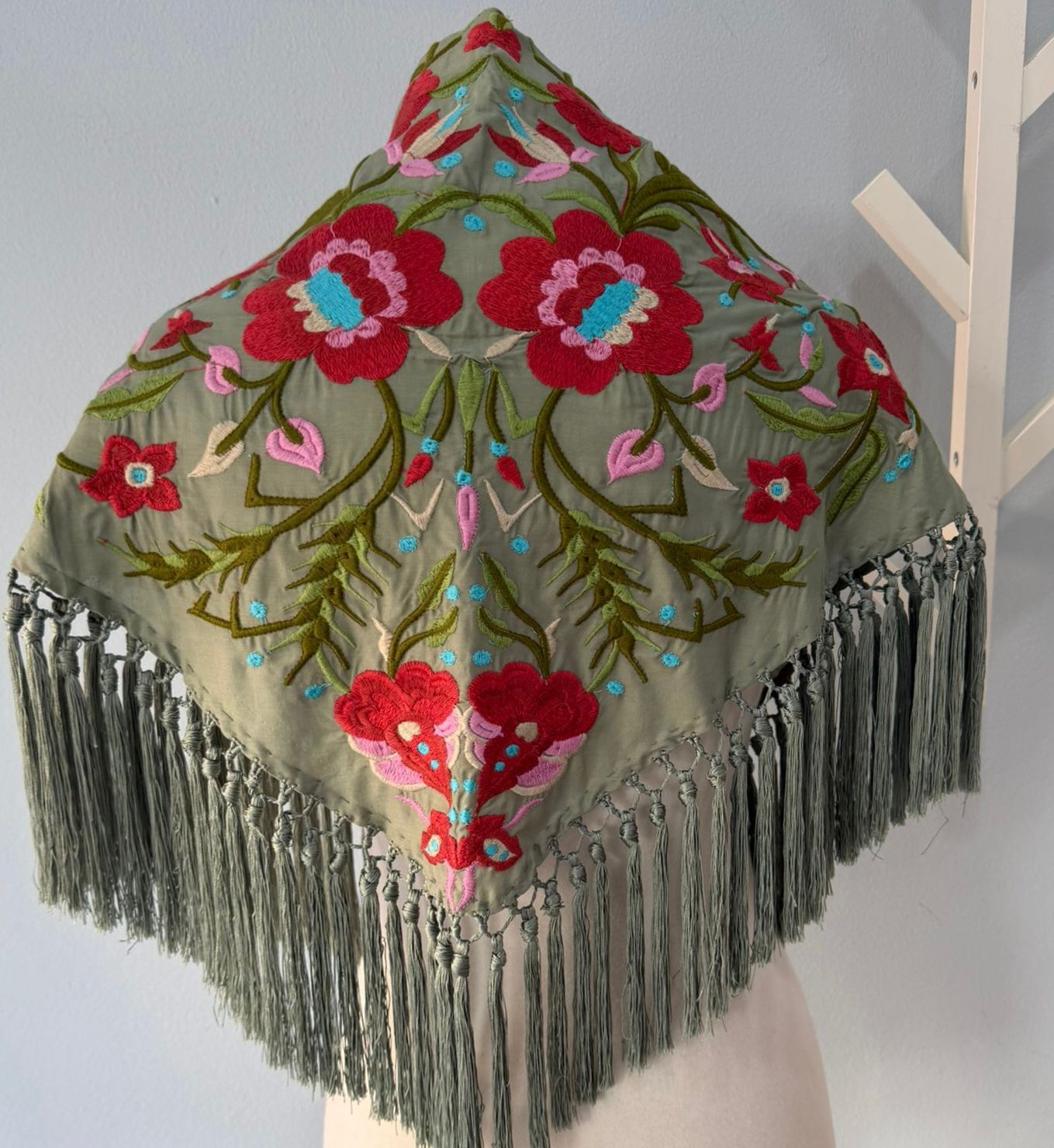 Mantón bordado de Cantillana, con flores de gran detalle y un acabado tradicional espectacular. Con flecos que le dan movimiento y un estilo único, acabado en pico.