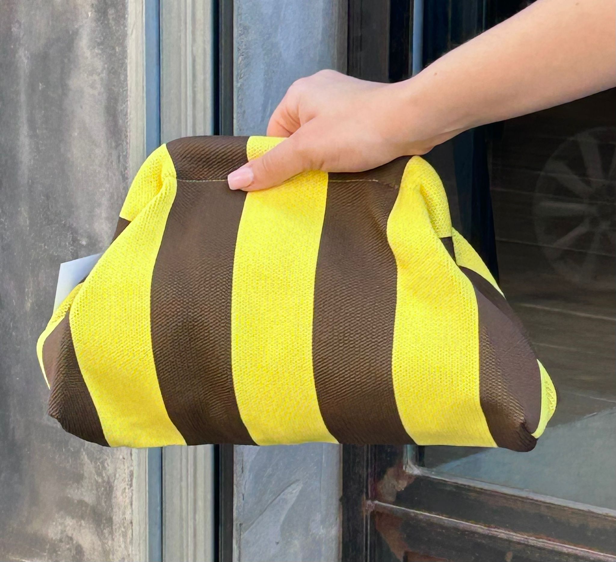 Bolso tipo clutch de punto de algodón, de rayas haciendo contraste los colores. Ligero, con una cadena dorada dentro que la puedes sacar para colgártelo. Perfecto para dar vida al look