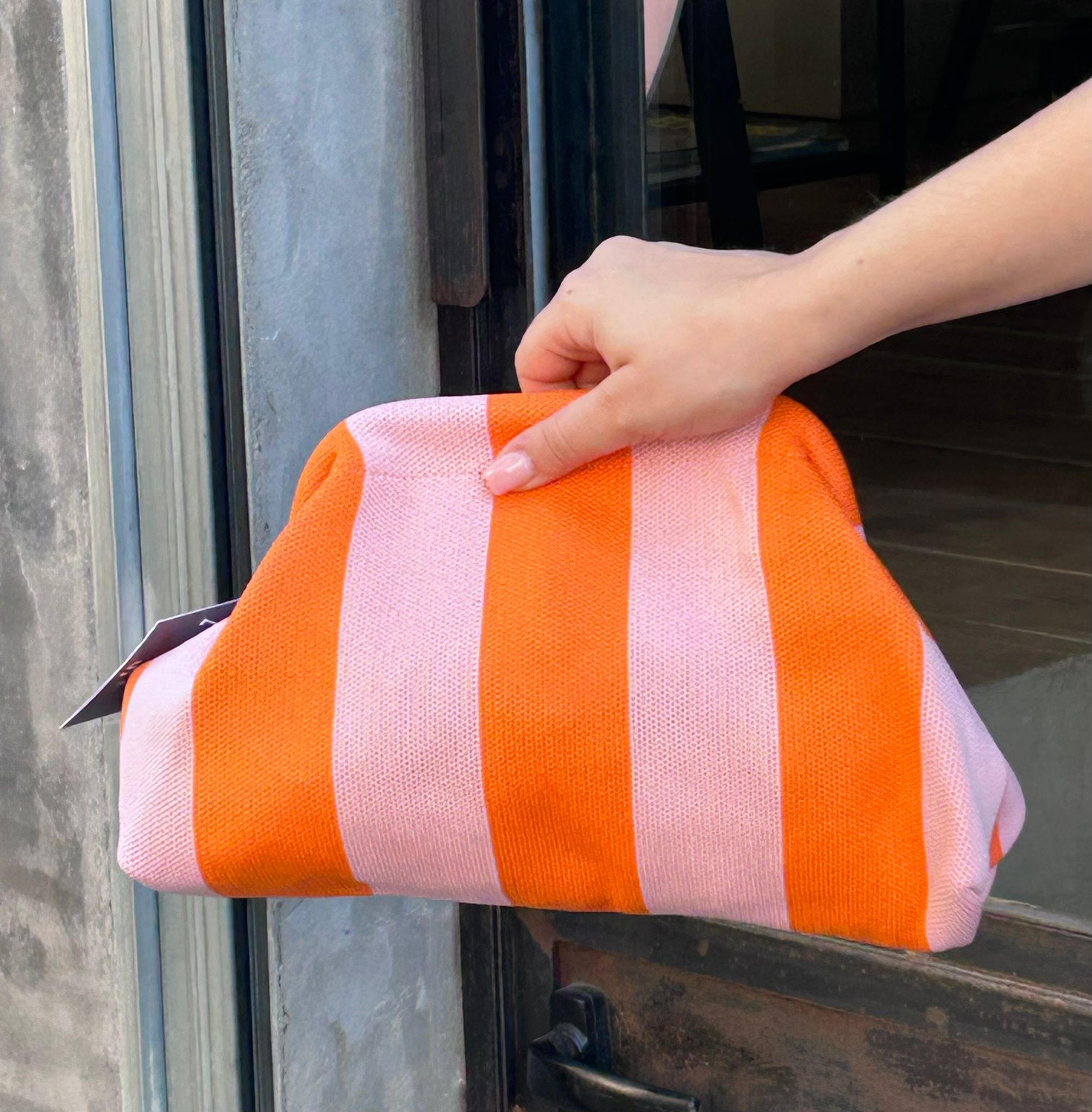 Bolso tipo clutch de punto de algodón, de rayas haciendo contraste los colores. Ligero, con una cadena dorada dentro que la puedes sacar para colgártelo. Perfecto para dar vida al look