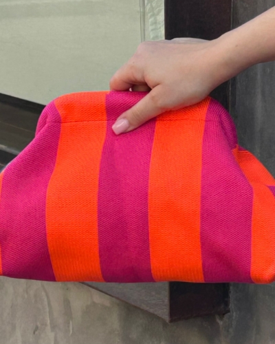 Bolso tipo clutch de punto de algodón, de rayas haciendo contraste los colores. Ligero, con una cadena dorada dentro que la puedes sacar para colgártelo. Perfecto para dar vida al look