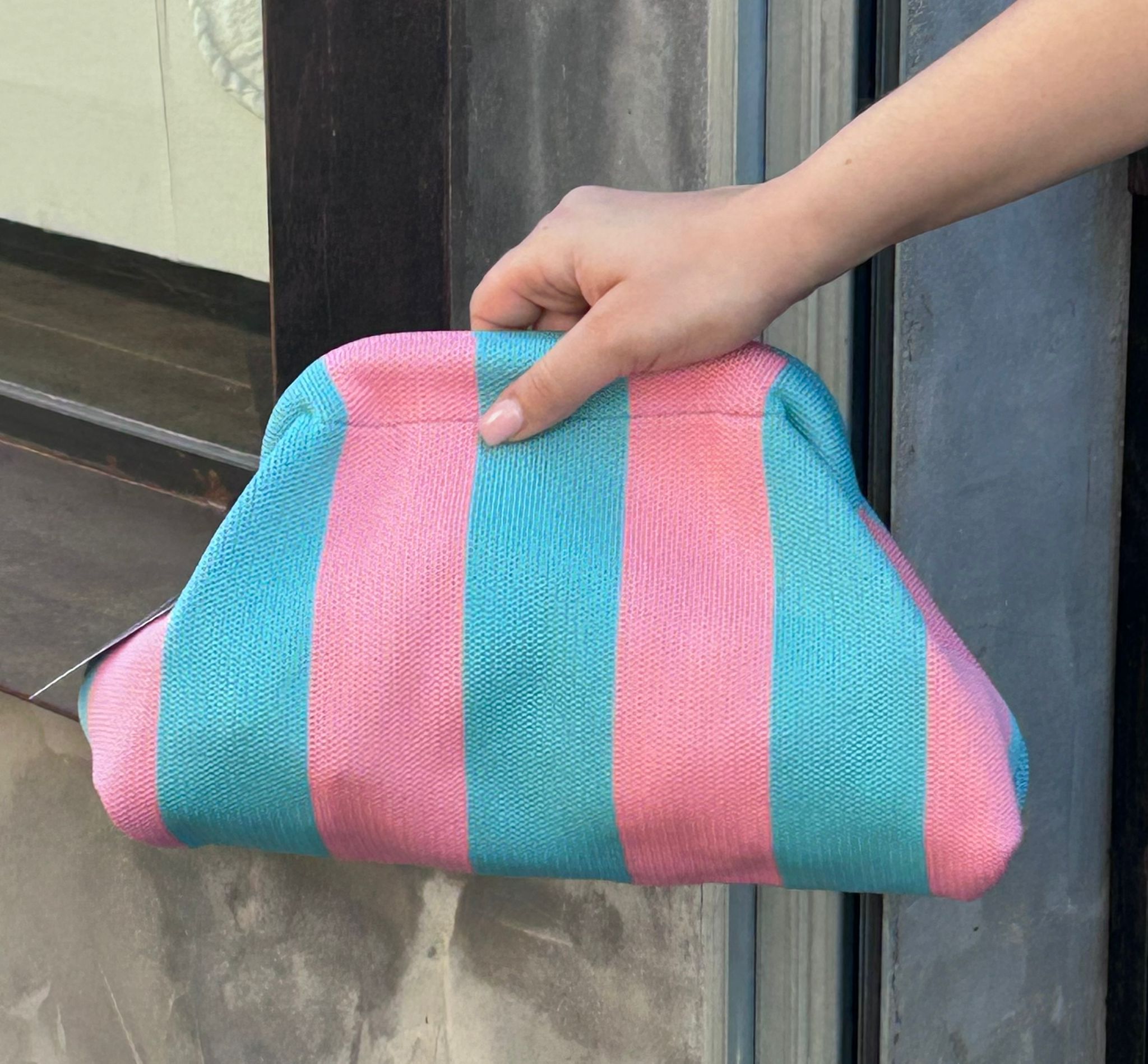 Bolso tipo clutch de punto de algodón, de rayas haciendo contraste los colores. Ligero, con una cadena dorada dentro que la puedes sacar para colgártelo. Perfecto para dar vida al look