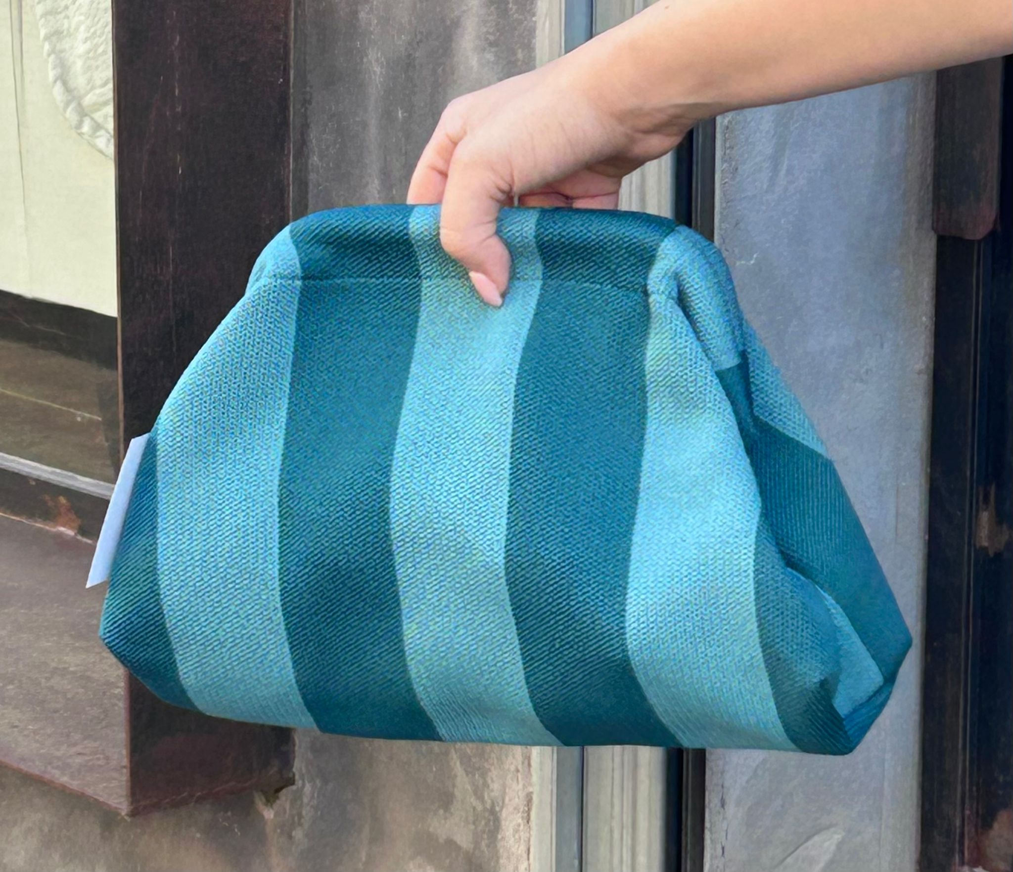 Bolso tipo clutch de punto de algodón, de rayas haciendo contraste los colores. Ligero, con una cadena dorada dentro que la puedes sacar para colgártelo. Perfecto para dar vida al look